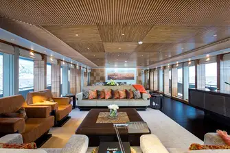 The main saloon has full-height windows, restful earth tones and pops of colour