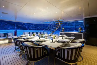 Open-air dining on the upper deck with a sun lounge aft