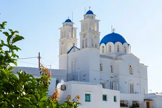 Explore the island admiring the white-washed architecture, as seen here with Agia Yannis church in the hilltop village of Apollonia, and indulging in mouthwatering cuisine 